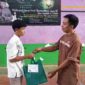 Guru SMAN 2 Ciamis tengah membagi sembako kepada siswa kurang mampu.