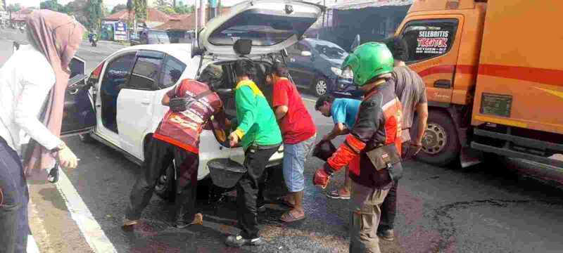 Mobil yang dikemudikan Tuti warga Saguling Baregbeg Ciamis disiram air untuk memdamkan api.