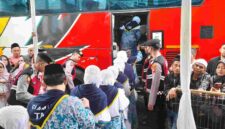 Calon jemaah haji berangkat menuju bus.