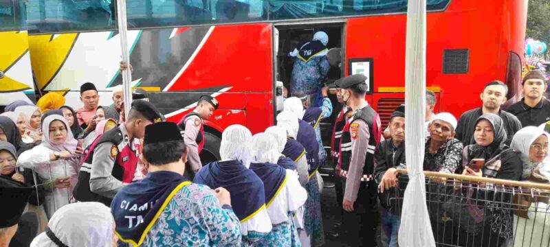 Calon jemaah haji berangkat menuju bus.