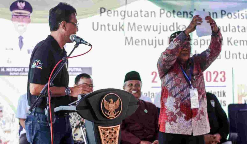 Bupati Ciamis Herdiat Sunarya tengah memberikan amplop putih sebesar Rp. 27 Juta.