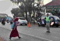 Siswa SD tengah menyeberang untuk bersekolah di Jalan Raya Margaluyu Ciamis.