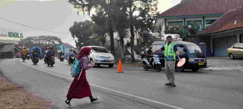 Siswa SD tengah menyeberang untuk bersekolah di Jalan Raya Margaluyu Ciamis.