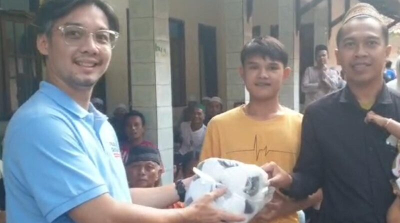 Relawan Caleg DPR RI Dapil Jabar X, Iwan Bule tengah memberikan bola kepada masyarakat Kuningan.