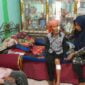Anah (55) korban gigitan anjing tengah dirawat oleh anaknya.