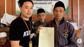 Penyerahan sertipikat tanah oleh Petugas PTSL.