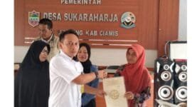 Ketua Tim 1 PTSL, Zaki Zukhruf, S.P. tengah menyerahkan sertipikat elektronik secara simbolis kepada masyarakat.