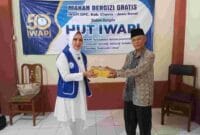 Wakil Ketua I IWAPI Kabupaten Ciamis, Hj. Rita Sumirat tengah membagikan nasi box kepada lansia.