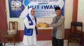 Wakil Ketua I IWAPI Kabupaten Ciamis, Hj. Rita Sumirat tengah membagikan nasi box kepada lansia.