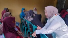Tina Wiryawati tengah menyapa masyarakat yang ingin melakukan pemeriksaan kesehatan gratis.