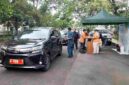 Kendaraan plat merah tengah diperiksa uji emisi oleh petugas.