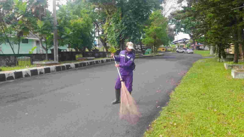 Petugas kebersihan sedang menyapu sampah disekitaran komplek Islamic Center Ciamis.