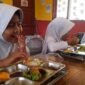 Siswi SDN 1 Kutawaringin tengah menyantap MBG dengan wajah gembira.