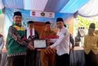 Kasi Penyelenggara Zakat dan Wakaf (PZW) Kemenag Kabupaten Ciamis, H. Wahidin, S.Ag., M.Pd.I (kanan), memberikan SK Kampung Zakat kepada Ketua UPZ Desa.