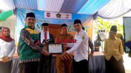 Kasi Penyelenggara Zakat dan Wakaf (PZW) Kemenag Kabupaten Ciamis, H. Wahidin, S.Ag., M.Pd.I (kanan), memberikan SK Kampung Zakat kepada Ketua UPZ Desa.