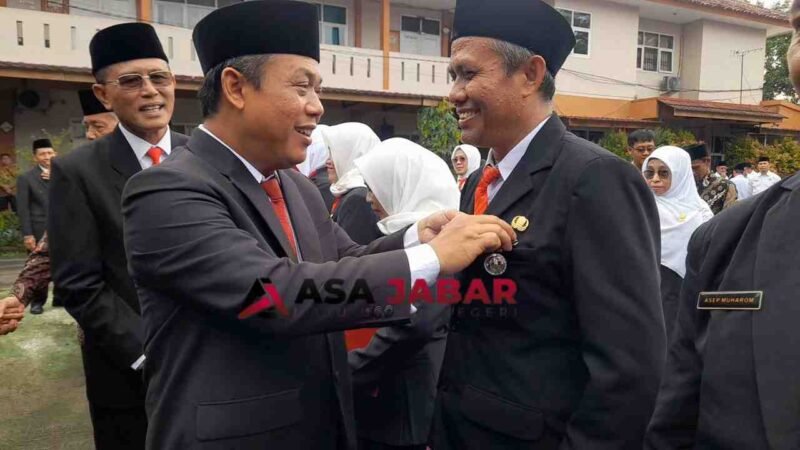 Kepala Kemenag Kabupaten Ciamis, H. Asep Lukman Hakim, M.Si menyematkan tanda kehormatan dari Presiden RI kepada Drs. E. Zenal Muttaqin, M.Pd.I. (kanan).