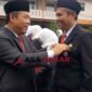 Kepala Kemenag Kabupaten Ciamis, H. Asep Lukman Hakim, M.Si menyematkan tanda kehormatan dari Presiden RI kepada Drs. E. Zenal Muttaqin, M.Pd.I. (kanan).