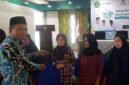 Kepala Kemenag, H. Asep Lukman Hakim tengah memberikan bantuan kepada penerima manfaat.