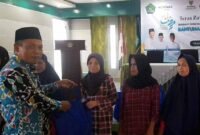 Kepala Kemenag, H. Asep Lukman Hakim tengah memberikan bantuan kepada penerima manfaat.