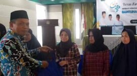 Kepala Kemenag, H. Asep Lukman Hakim tengah memberikan bantuan kepada penerima manfaat.