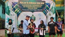 Ketua KKMTs, H. Dadang tengah memberikan piala kepada pemenang Porseni.
