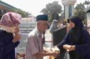 Panitia membagikan makanan gratis kepada jemaah usai Salat Jumat dalam program 