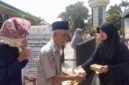 Panitia membagikan makanan gratis kepada jemaah usai Salat Jumat dalam program