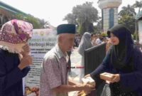 Panitia membagikan makanan gratis kepada jemaah usai Salat Jumat dalam program 