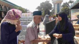 Panitia membagikan makanan gratis kepada jemaah usai Salat Jumat dalam program 